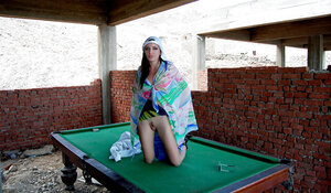 Brunette broad poses barely clothed teasing on pool table