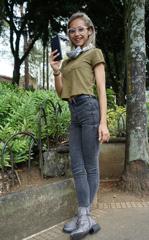 Veronica Leal poses on hood in green shirt & tight jeans