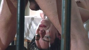 Slim brunette facialized after fetish sex with master in strange prison cell