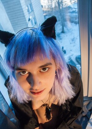 Shy alt kitten while sitting near window seductively demonstrates jugs and pussy