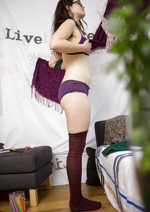 Tempting lassie with glasses puts violet lingerie and green dress on