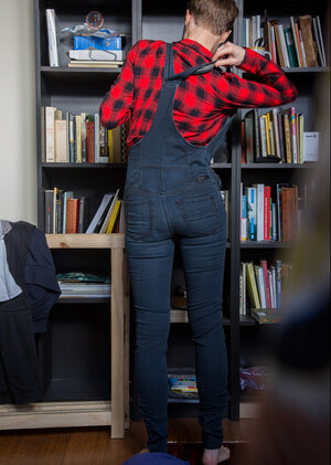 Nude short-haired gal with glasses puts clothes on right in the library