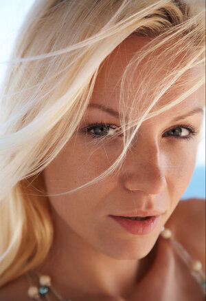 Blonde girl shows off her tasty-looking body posing naked on the couch outdoors