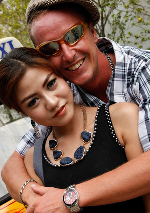 Eccentric tourist coaxes modest Oriental teen to pose outdoors near rickshaw