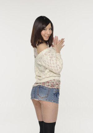 Young-looking Japanese broad poses in short skirt that accentuates her long legs