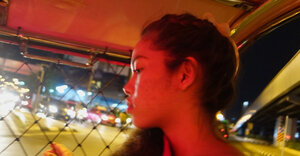 Thai floozy in a red dress never stops smiling even in the backseat of a taxi