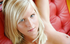 Hot blonde with seductive big tits displays sweet twat on the red chair